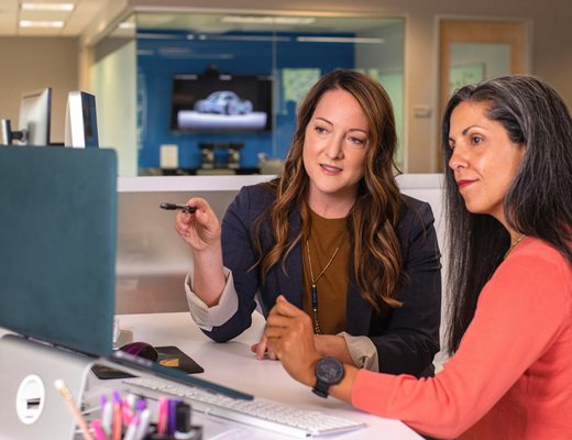 Two colleagues collaborating on procurement strategy at a desk